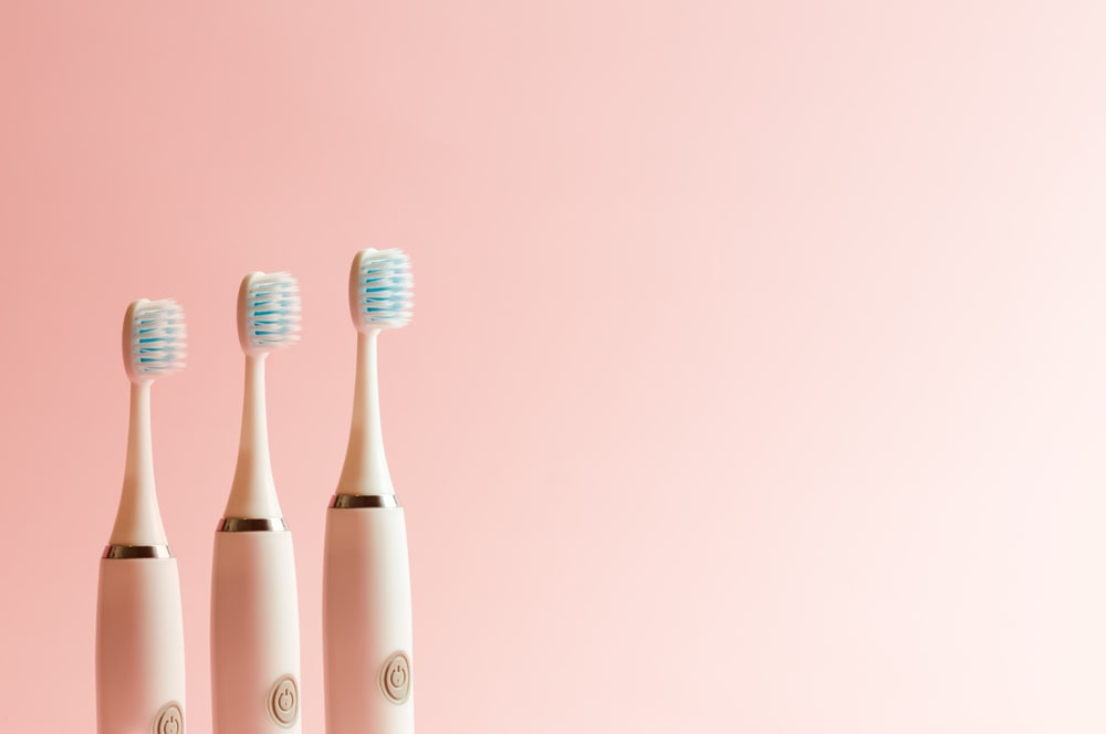 brosses à dents électriques sur fond rose