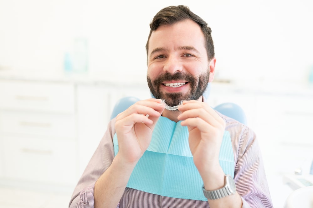 homme et son traitement d'orthodontie invisible
